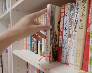 棚板の幅にテープを切って、棚板手前に貼り付けます。本を手前に滑らせると、テープのところでピタッと止まります。