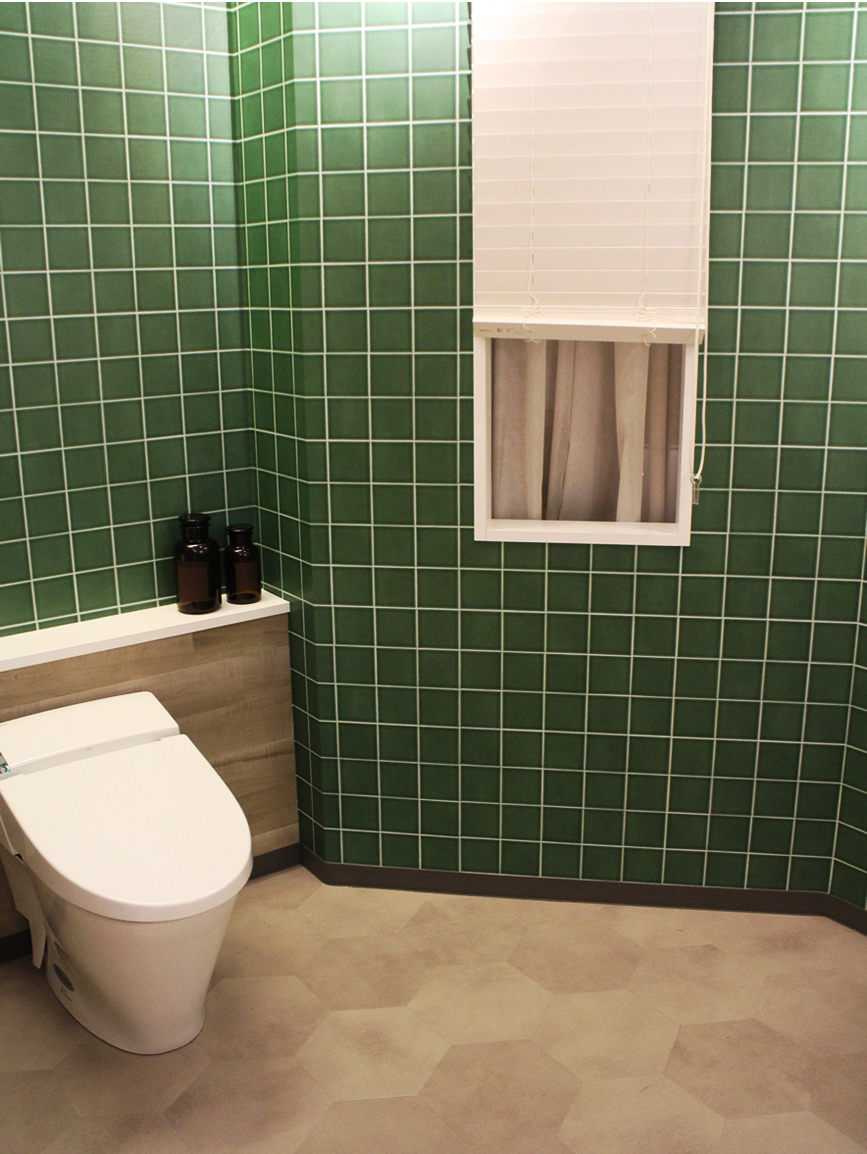 トイレに貼られた緑色のタイル柄の壁紙。
