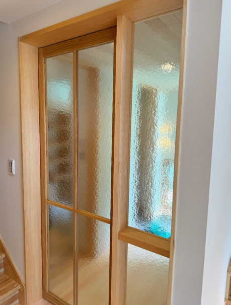 室内から玄関を見たところ。型板ガラスをはめ込んだ造作の建具です。