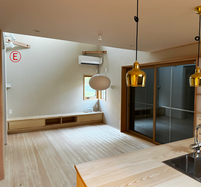 1階のダイニングから見たリビングの吹き抜け。リビングに設置したエアコンの空調効果が2階まで届きます。Ⓔスライドレールとスポットライト。