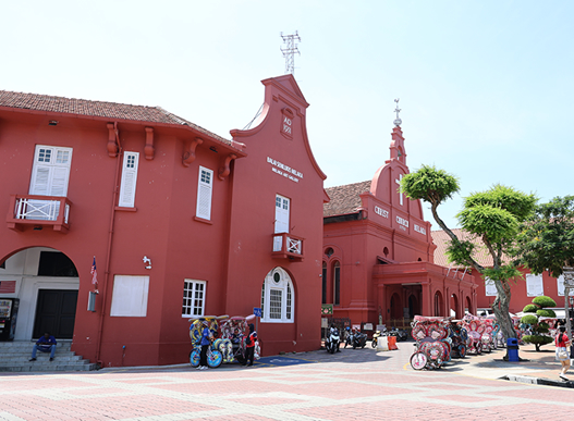 写真①：マラッカのキリスト教会やスタダイスの、サーモンピンクのレンガ造りの建物。