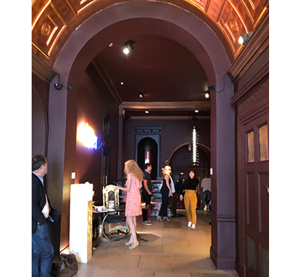 写真③：天井高のあるイギリス歴史建物のカフェの入り口は、深く濃いバイオレットカラー。