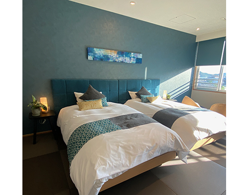 写真①：寝室のファオーカルポイントとなる、ベットヘッド後ろの壁は、思い切った深いカラーは有効的。