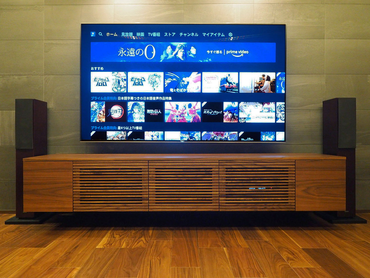 テレビボードの両端の底面へスピーカーケーブル用の穴を開け、センタースピーカーとサブウーファーは内部に設置。